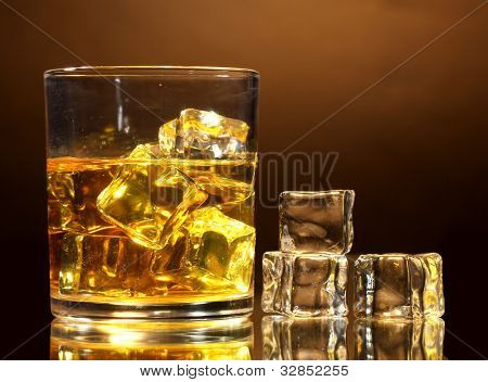 verre de whisky et de la glace sur fond marron