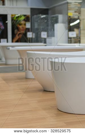 White Bathtubs In A Hardware Store. The Concept Of Choosing And Installing Bathtubs. Vertical Photo