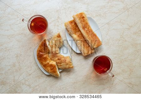 Placinta, traditional Moldovan pastries at the table in cafe in Chisinau, Moldova. Two plates of placentas and two tea top view.