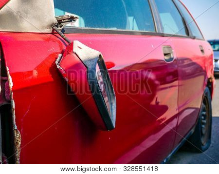 Broken Mirror On Old, Red Abandoned Car In The Parking Lot.