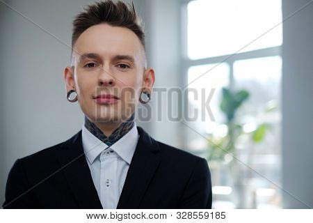 Portrait of alternative model with earplugs and tattoo