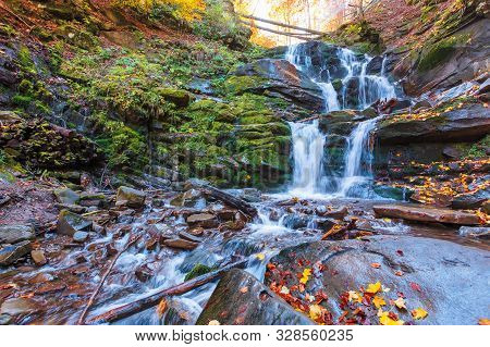 Waterfall Shypot Of Carpathian Mountains In Autumn. Powerful Stream Of Water. Brown Foliage On The R