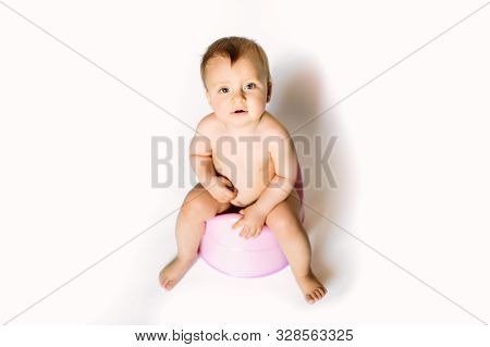 Childrens Legs Hanging Down From A Chamber-pot On A White Background