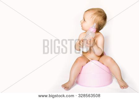 Charming Photo Of Cute Baby Girl Holding A Boottle With Baby Milk And Sitting On A Pink Potty. Isola