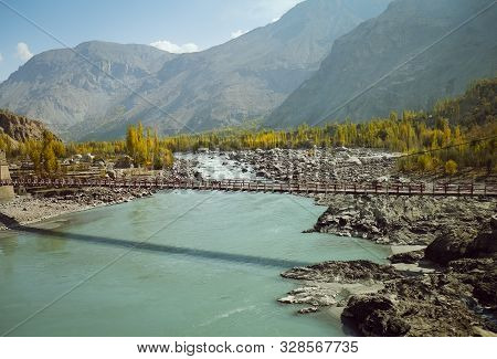 Indus River Flowing Through Mountainous Area In Ghanche District With A View Of Colorful Trees In Au