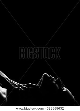 Young Topless Sensual Woman With Closed Eyes Lying On Black Background With Copy Space, Hand On Neck