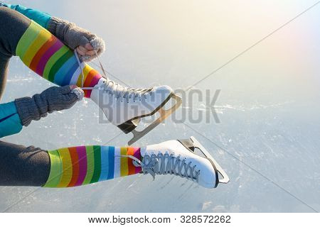Pair Of Legs Shod Ice Skates On Ice In Winter