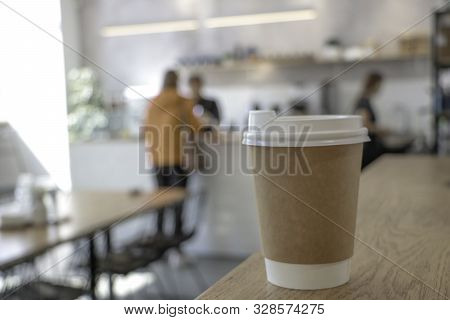 Mock Up With A Cup Of Coffee. A Glass Is On The Table In A Cafe, Selling Coffee In The Background. C