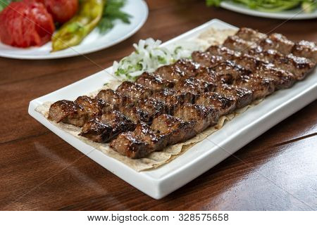 Fast food. Eastern food. Shish kebab, lyulya-kebab. Dishes of oriental cuisine lying in plte and dec