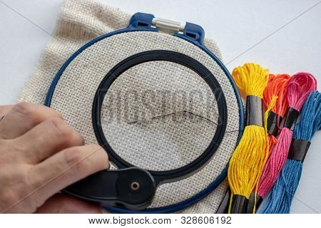 An Elderly Woman With Wrinkled Fingers Holds A Magnifying Glass And Through The Transparent Glass Is