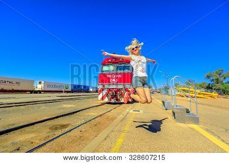 Alice Springs, Northern Territory, Australia - Aug 29, 2019: Tourist Woman Jumping In Front Of The G