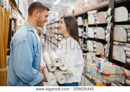 Couple choosing wallcovering in hardware store
