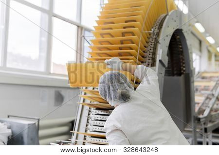 The Confectioner-technologist Controls The Quality Of Baking Wafers On The Conveyor In The Shop Of T