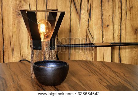 Original Lamp From An Old Wooden Bar And A Protective Metal Grill Around The Lamp And A Black Clay B