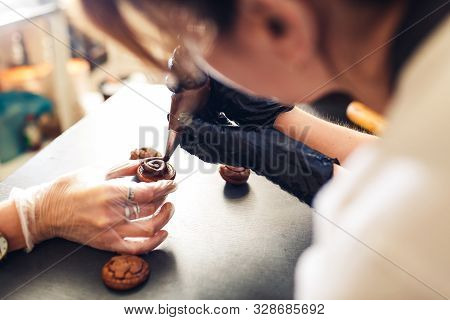 Pastry Chef Squeezes Chocolate Cream From A Pastry Bag Onto Cookies. Making Chocolate Cookie Sandwic