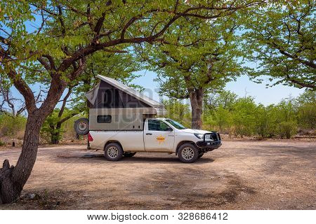 Halali, Namibia - March 27, 2019 : Tent Located On The Roof Of A Pickup 4x4 Car Parked Under Trees O