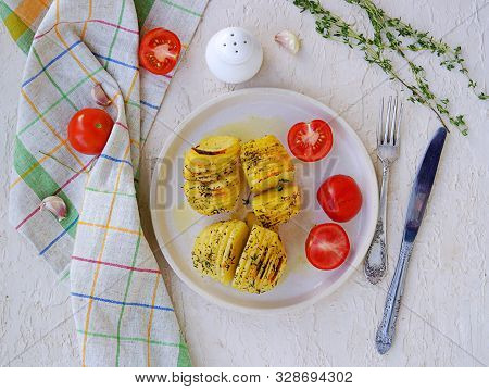 Hasselback Potatoes On A White Clay Plate On A Light Concrete Background. Potato Recipes. Thanksgivi