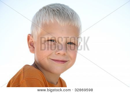 Jonge blonde jongen glimlacht in oranje shirt