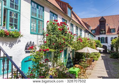 Colorful Flowers At The Facade Of A White House In Flensburg, Germany