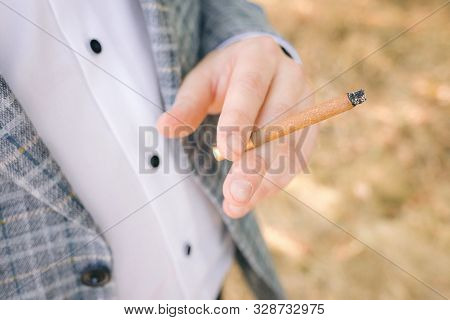 Man Smoking Cigarette. Male Hand Holding Cigarette