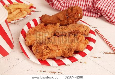 Perfect fried chicken pieces fast food on red white striped plate