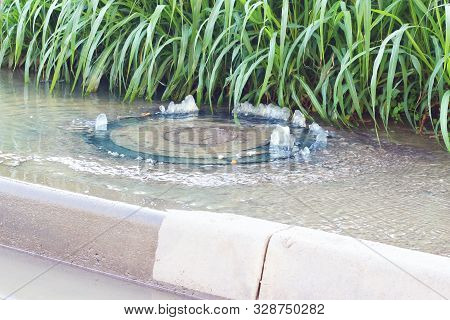 Accident Sewerage System. Water Flows Over The Road From The Sewer. Water Flows Over The Road From T