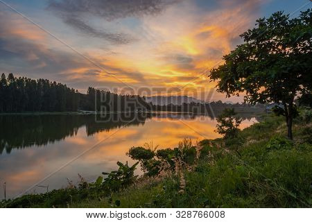 Beautiful View Of Twilight Silhouette Sunset On The Water Reservoir While The Sky After Sunset Has O
