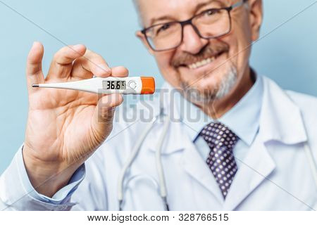 Portrait Of A Handsome Senior Doctor Holding A Thermometer In His Hands, On A Thermometer, The Norma