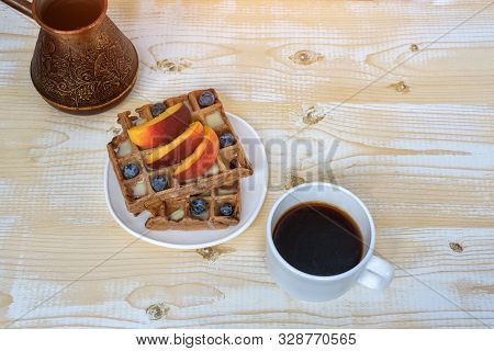 Chocolate Belgian Waffles With Fruits, Cup Of Coffee And Cezve On White Wooden Background. Delicious