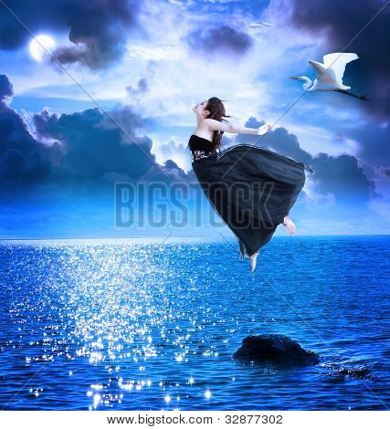 Belle fille se jetant dans le ciel bleu nuit