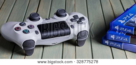 Izhevsk, Russia - 17 October, 2019: White Joystick Game Console Playstation. Multiple Ps4 Games. Blu