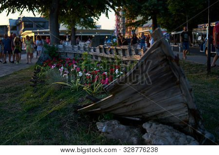 Old Wooden Boat As A Decoration (flowerbed With Flowers) On The Streets Of The Seaside Town. Pomorie
