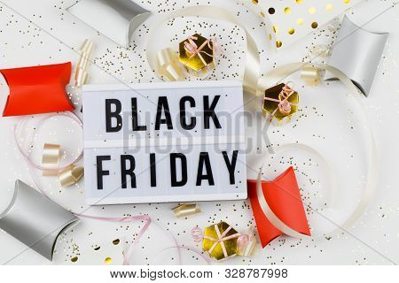 Black Friday Sale Text On White Lightbox, Golden Stars And Packaging Around On White Background