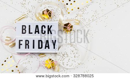 Black Friday Sale Text On White Lightbox, Golden Stars, Holiday Ribbon And Box Around On White Backg