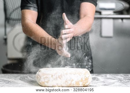 Baker Claping Hands With Flour In Restaurant Kitchen .