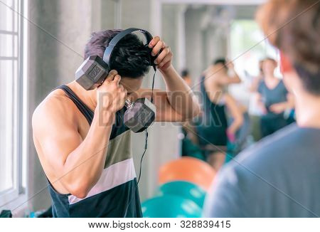 Strong Asiam Sport Man In Gym Is Putting On Music Headphone Before Working Out In The Gym For Modern