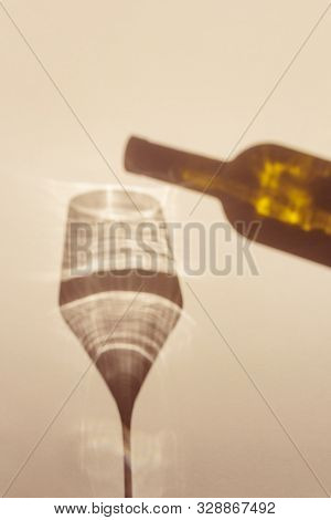 A Spectacular Long Shadow Falls From The Glass With Wine, Next To It Is The Shadow Of A Bottle Of Wi
