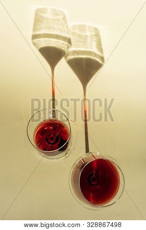A Spectacular Long Shadow Falls From The Glass With Wine, Next To It Is The Shadow Of A Bottle Of Wi