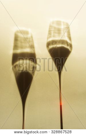 A Spectacular Long Shadow Falls From The Glass With Wine, Next To It Is The Shadow Of A Bottle Of Wi