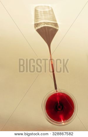 A Spectacular Long Shadow Falls From The Glass With Wine, Next To It Is The Shadow Of A Bottle Of Wi