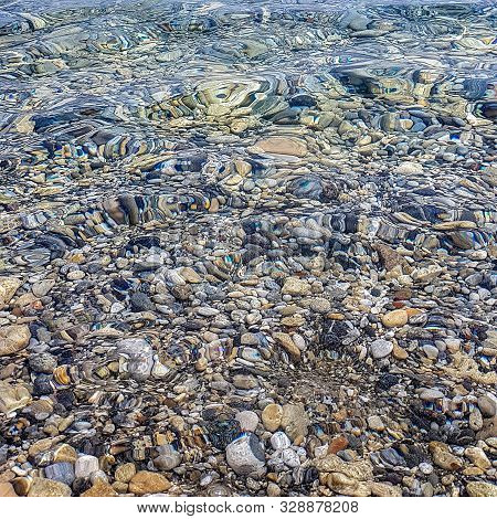 The Seabed Is Strewn With Colorful Pebbles. Can Be Used As Wallpaper, Texture, Background.