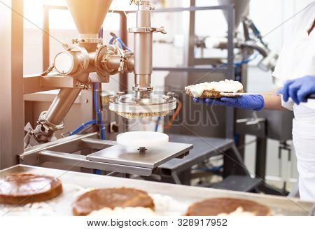 Modern Equipment For The Manufacture Of Cakes. Smear Cream On Cake. Confectionery, Automatic