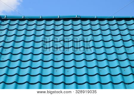 Turquoise Metal Tiles On The Roof Of The House. Modern Roofing Materials