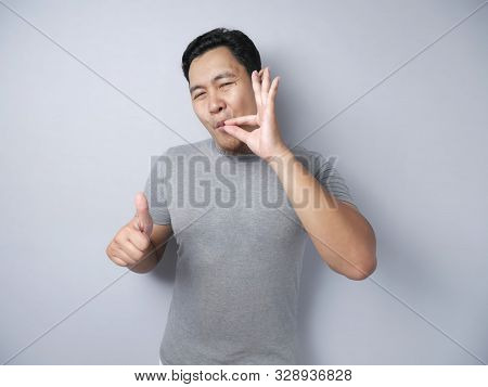 Portrait Of Young Asian Man Making Delicious Hand Gesture, Close Up Head And Shoulder Portrait