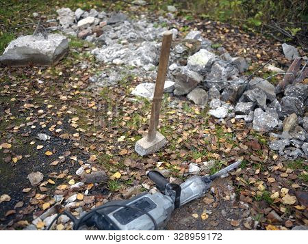 Pnaumatic Hammer, Sledgehammer; And Pieces Of Concrete Abandoned On The Ground