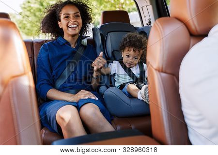Happy Mother And Her Son Sitting On A Backseat While Traveling In A Car