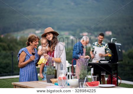 Multigeneration Family With Wine Outdoors On Garden Barbecue, Grilling.