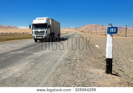 Pamir Highway Or Pamirskij Trakt And White Truck. Landscape Around Pamir Highway M41 International R