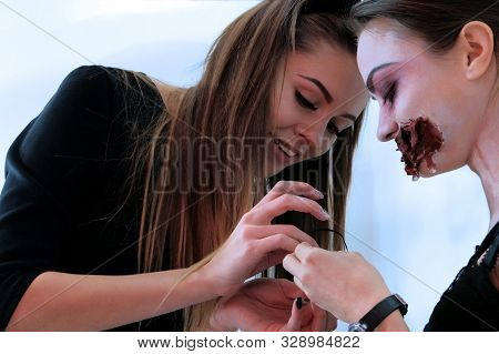 Two Beautiful Girls Have Fun And Prepare A Costume For The Day Of The Dead Or Halloween. Preparing F