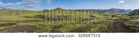 Panoramic Landscape With Blue River Stream, Green Hills, Snow-capped Mountains, Meadow And Lush Moss